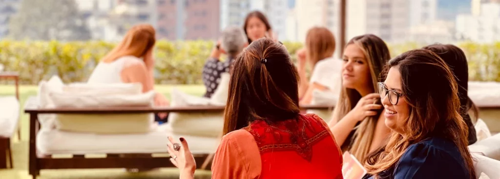 Mulheres conversando no sofá no gramado em um evento na Cosy Casa Mirante